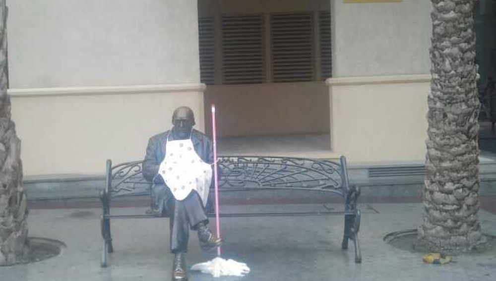 Estatua de Sixto Marco con delantal y una fregona