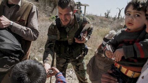 Varios soldados sirios ayudan en la evacuaci&oacute;n de un nuevo grupo de civiles de Guta Oriental