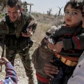 Varios soldados sirios ayudan en la evacuación de un nuevo grupo de civiles de Guta Oriental