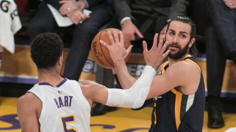 Ricky Rubio busca a un compa&ntilde;ero mientras es defendido por Hart
