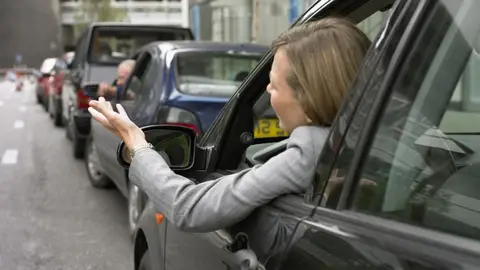 Una mujer increpa a otros conductores en un atasco. Una mujer increpa a otros conductores en un atasco.