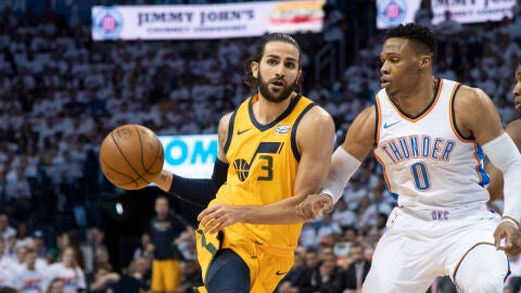 Ricky Rubio ataca mientras es defendido por Russell Westbrook