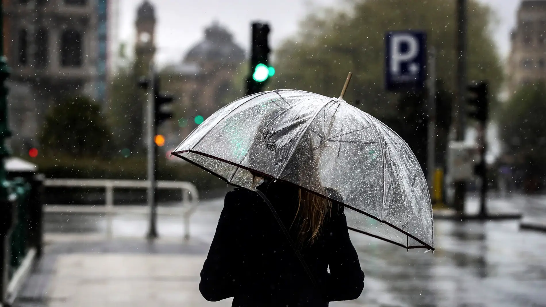 Una mujer camina bajo su paraguas