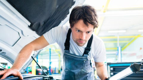 Mecánico reparando un coche en el taller