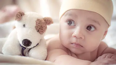 Un bebé con su peluche Un bebé con su peluche