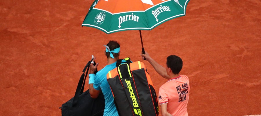 Rafa Nadal abandona la Philippe Chatrier bajo un paraguas Rafa Nadal abandona la Philippe Chatrier bajo un paraguas