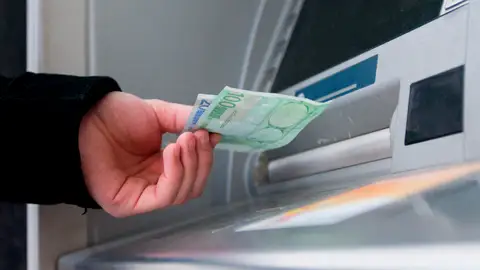 Archivo Un hombre saca euros de un cajero automátic