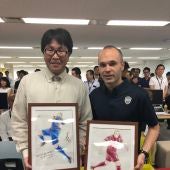 Takahashi posa con Iniesta y sus dos dibujos