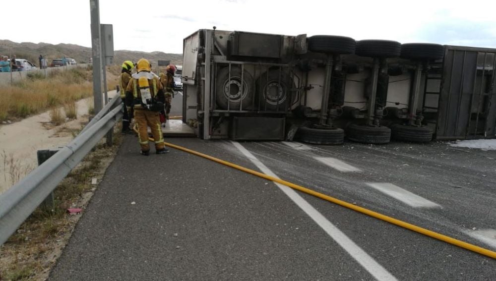Bomberos junto al camión siniestrado en Elche