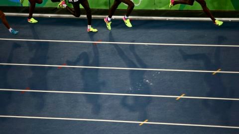 Varios atletas corren en una pista de atletismo
