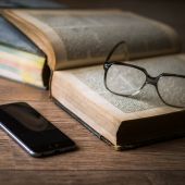 Imagen de un libro, unas gafas y un teléfono móvil