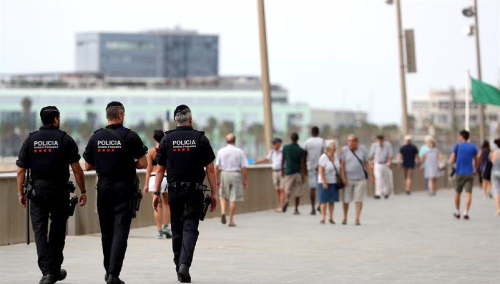 Tres Mossos d'Esquadra patrullan por el paseo marítimo de Barcelona