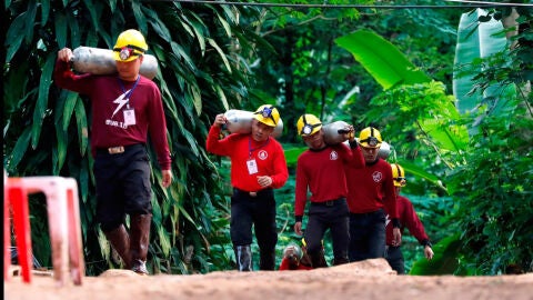 Miembros de los servicios de rescate de Tailandia cargan con botellas de ox&iacute;geno