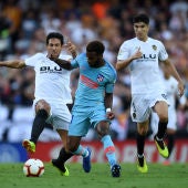 Lemar conduce el balón ante la presión de Parejo y Carlos Soler