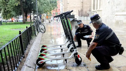 Unos agentes de la Policía Local trabajan en la retirada de los patinetes Unos agentes de la Policía Local trabajan en la retirada de los patinetes
