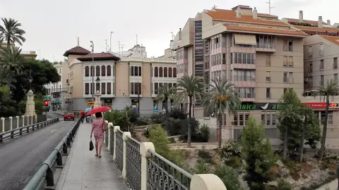 Ciudadanos con paraguas en el Puente de Canalejas de Elche. Ciudadanos con paraguas en el Puente de Canalejas de Elche.