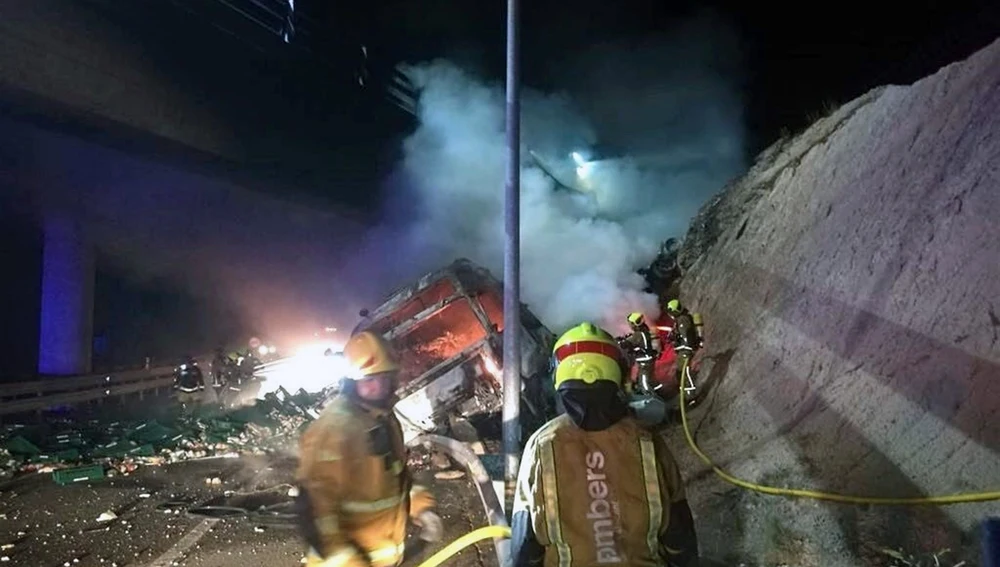 Bomberos en las labores de extinción del incendio del camión siniestrado