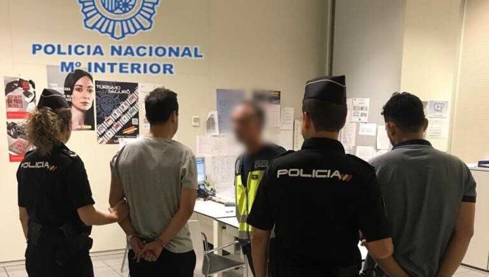 Agentes de la Policía Nacional con los detenidos en el Aeropuerto Alicante-Elche