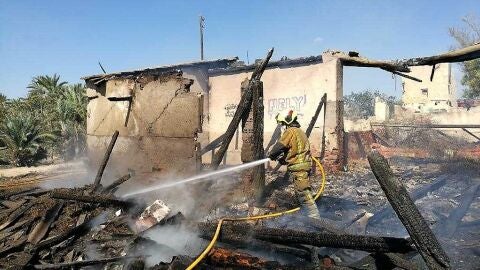 Bombero de Elche apagando el fuego originado en la casa de campo
