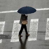 Una mujer se protege con un paraguas ante la lluvia