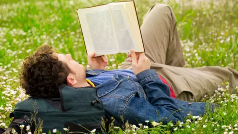 Un chico leyendo en un parque Un chico leyendo en un parque