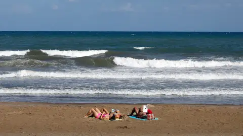 Tres personas toman el sol, el pasado mes de septiembre en la playa de la Malvarrosa de Valencia Tres personas toman el sol, el pasado mes de septiembre en la playa de la Malvarrosa de Valencia