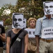 Varias personas sostienen pancartas y máscaras del cineasta ucraniano encarcelado en Rusia, Oleg Sentsov