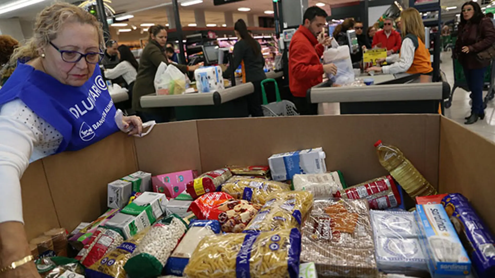 Una voluntaria del Banco de Alimentos colocando los alimentos donados por los clientes de un supermercado