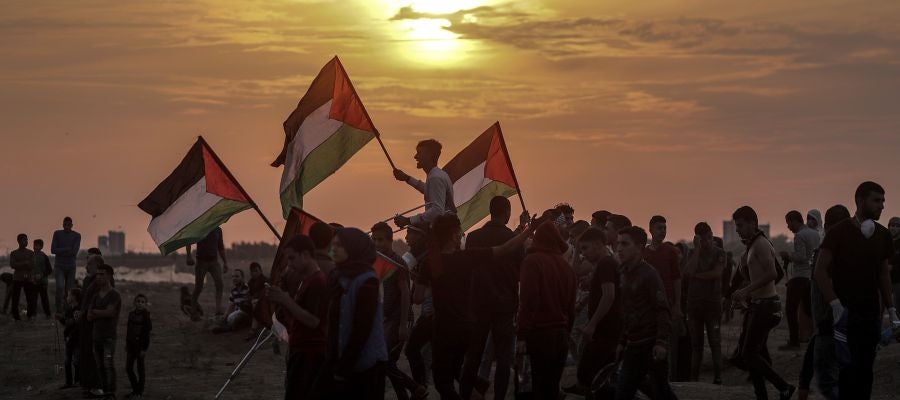 Varios palestinos ondean sus banderas durante enfrentamientos con soldados israelíes en la Franja de Gaza Varios palestinos ondean sus banderas durante enfrentamientos con soldados israelíes en la Franja de Gaza