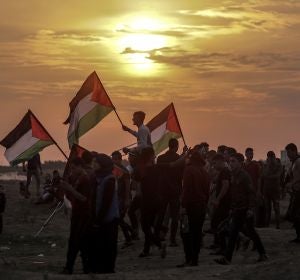 Varios palestinos ondean sus banderas durante enfrentamientos con soldados israelíes en la Franja de Gaza Varios palestinos ondean sus banderas durante enfrentamientos con soldados israelíes en la Franja de Gaza