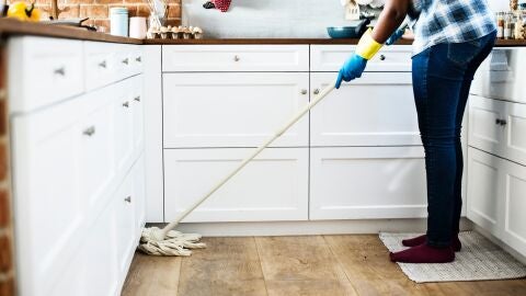 Una mujer friega el suelo de la cocina de su casa