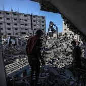 Un par de palestinos caminan entre los escombros en Gaza