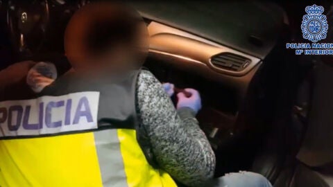 Un agente de la Polic&iacute;a Nacional de Elche abre el compartimento de un coche en el que se oculta droga