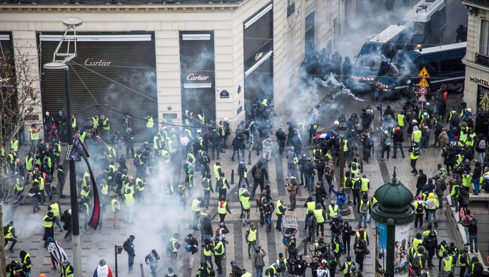 Chalecos amarillos se enfrentan a las fuerzas policiales durante una manifestación cerca de los Campos Elíseos en París