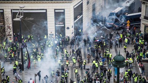 Chalecos amarillos se enfrentan a las fuerzas policiales durante una manifestaci&oacute;n cerca de los Campos El&iacute;seos en Par&iacute;s
