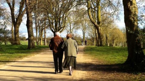 Dos personas mayores caminan por un espacio natural
