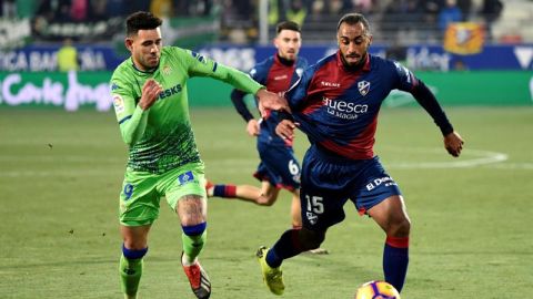 El defensa del Huesca Carlos Akapo lucha el bal&oacute;n con Antonio Sanabria, delantero del Real Betis