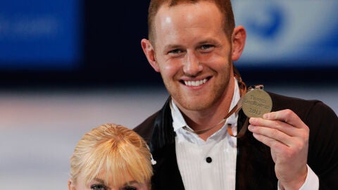 John Coughlin (derecha de la imagen) sonr&iacute;e con una medalla