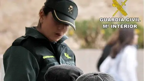 Una agente de la Guardia Civil conversa con dos personas mayores Una agente de la Guardia Civil conversa con dos personas mayores