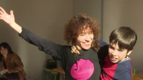 Imagen de una profesora de danza junto a un ni&ntilde;o con autismo en una clase de danza