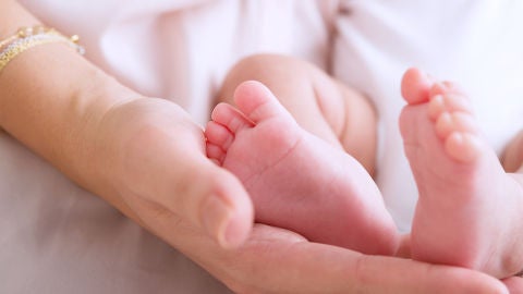 Una madre sosteniendo los pies de su beb&eacute;