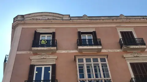 El símbolo de "sinsajo" colgado desde el balcón de Mes per Mallorca en el Parlament balear El símbolo de "sinsajo" colgado desde el balcón de Mes per Mallorca en el Parlament balear