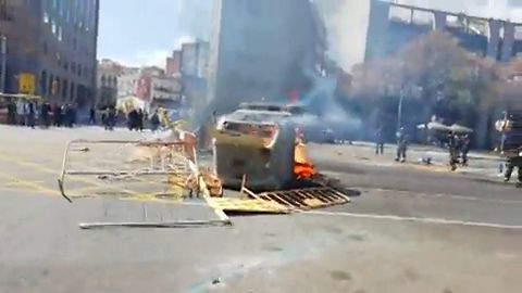 Manifestantes queman contenedores y lanzan objetos contra el acto de Vox