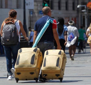 Varios turistas con sus maletas en las calles de Madrid Varios turistas con sus maletas en las calles de Madrid