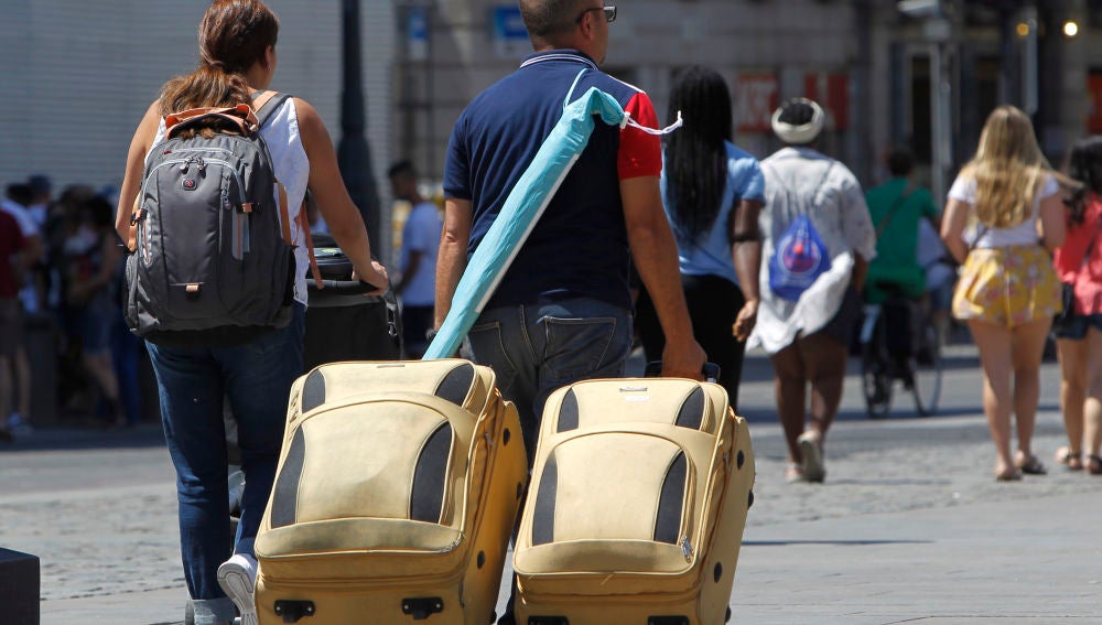 Varios turistas con sus maletas en las calles de Madrid