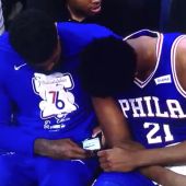 Amir Johnson y Joel Embiid miran el móvil durante el partido contra los Nets