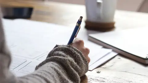 Una persona escribiendo Una persona escribiendo