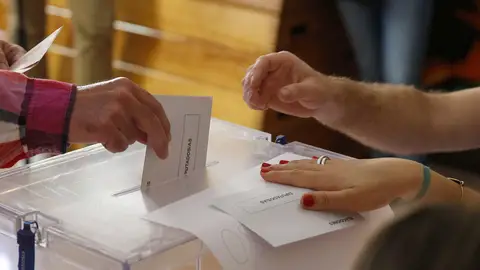 Imagen de archivo de un votante depositando su papeleta en las urnas. Imagen de archivo de un votante depositando su papeleta en las urnas.