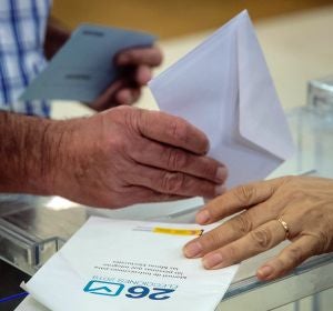 Una ciudadana deposita su voto en la urna en un colegio electoral Una ciudadana deposita su voto en la urna en un colegio electoral