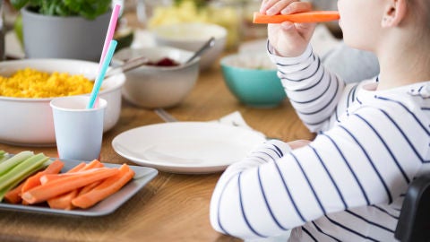 Ni&ntilde;o comiendo palitos de zanahoria